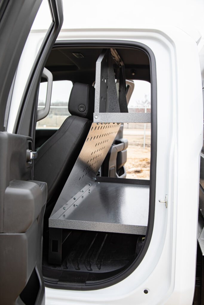 A Cargo Deck storage product in the backseat of a white truck.